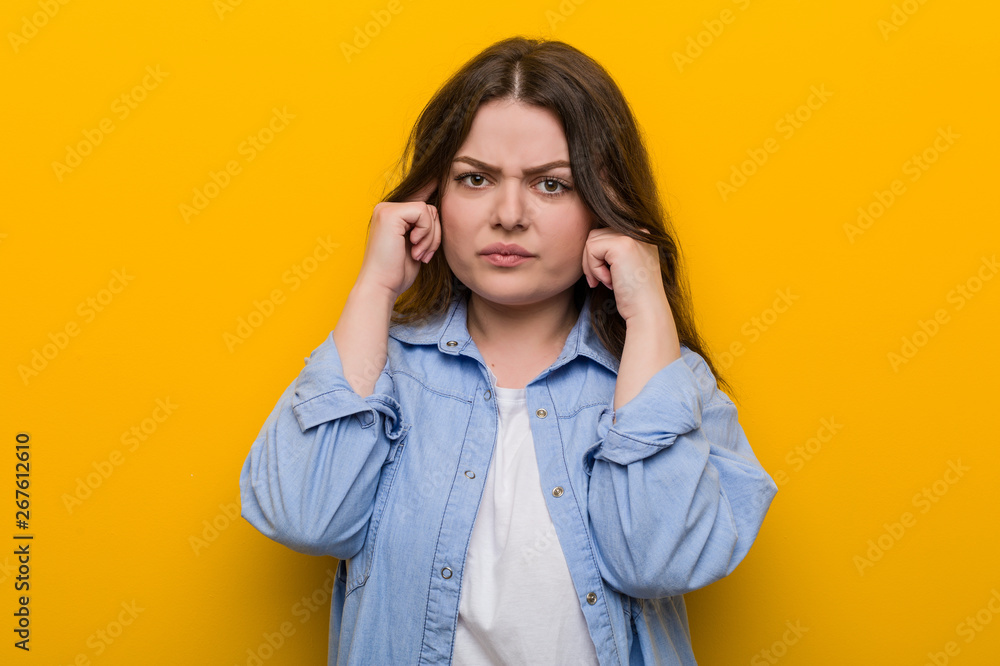 Young curvy plus size woman focused on a task, keeping him forefingers pointing head. Young curvy plus size woman focused on a task, keeping him forefingers pointing head.