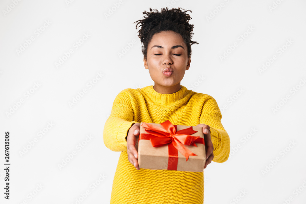 Beautiful young african excited emotional happy woman posing isolated over white wall background holding present gift box. Beautiful young african excited emotional happy woman posing isolated over white wall background holding present gift box.