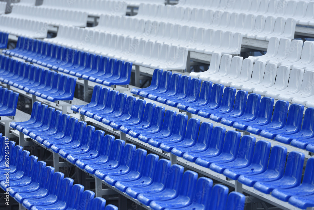 Empty stands with wet seats in red, white and blue in the stadium after the rain Empty stands with wet seats in red, white and blue in the stadium after the rain