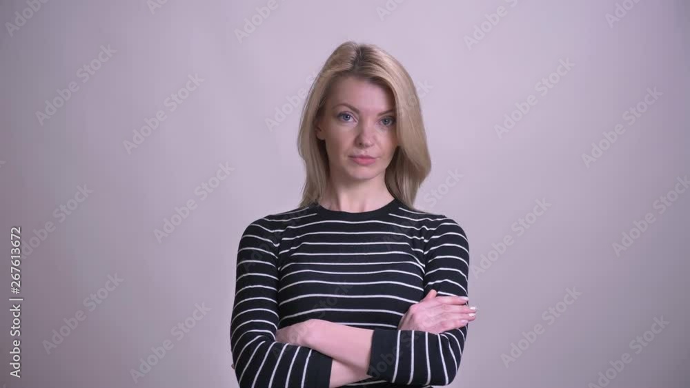 Closeup portrait of adult attractive blonde caucasian female having crossed over chest looking at camera with background isolated on white Closeup portrait of adult attractive blonde caucasian female having crossed over chest looking at camera with background isolated on white