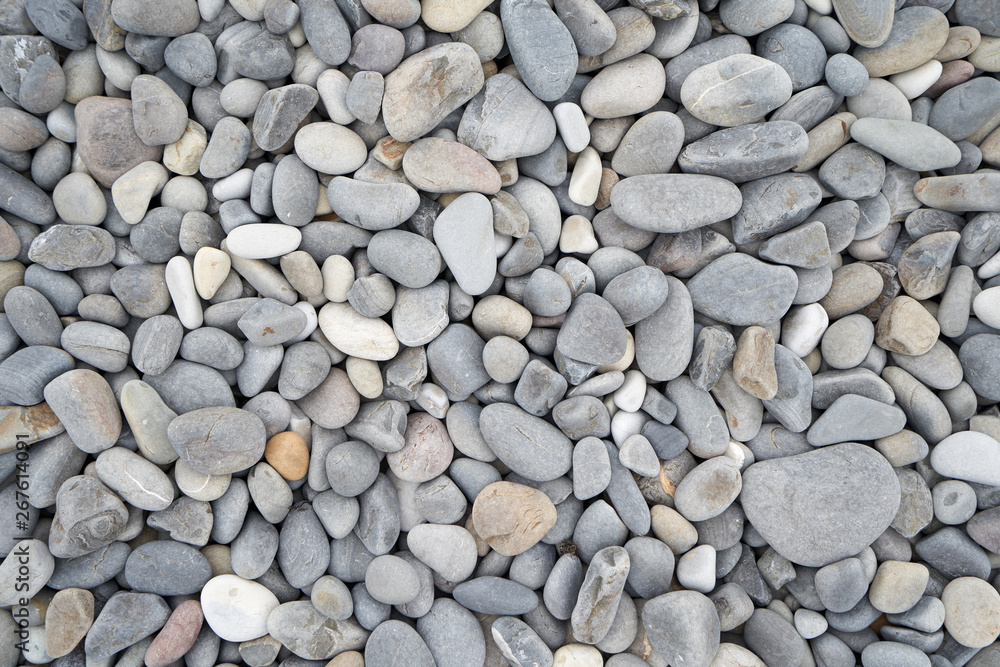Texture of gray oval pebble stones next to the sea. Close-up Texture of gray oval pebble stones next to the sea. Close-up