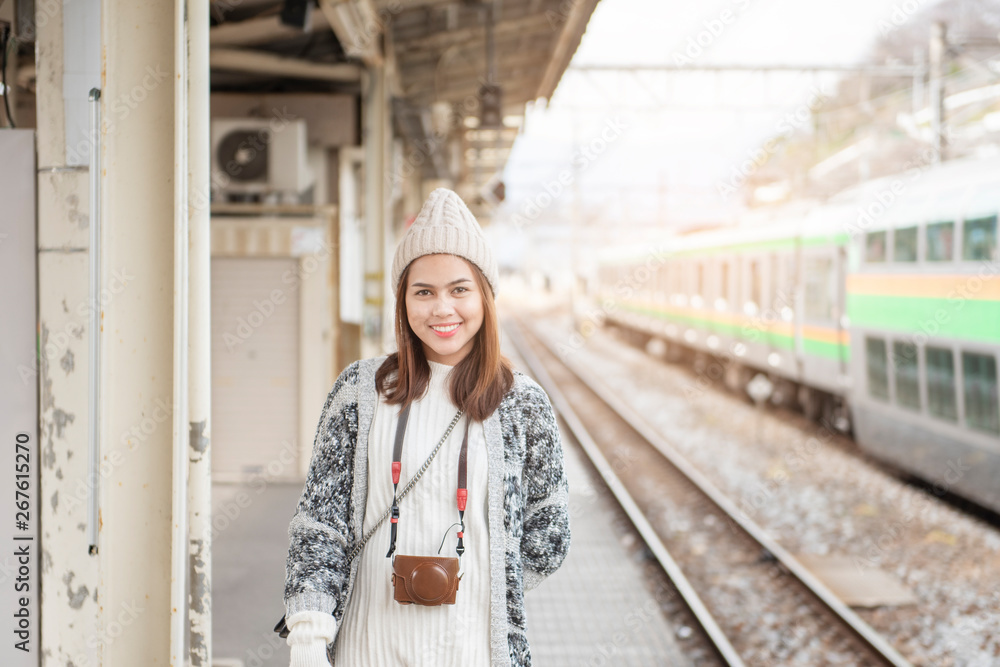 Beautiful tourist  woman is standing on Railway platform  with her Map