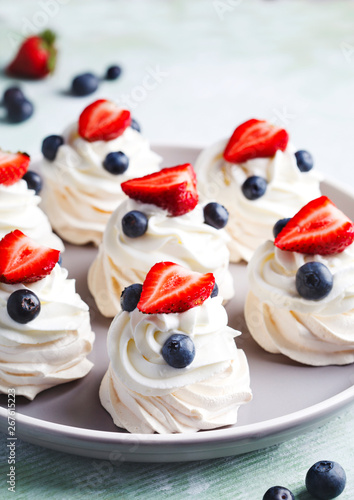 Mini Pavlova meringue with whipped cream and berries.