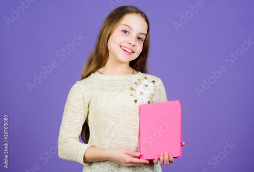 Shes a student of language and literature. Cute little child holding book in English literature. Adorable small girl reading literature book. Fiction and scientific literature, copy space photo