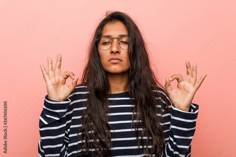 Young intellectual indian woman relaxes after hard working day, he is performing yoga. Young intellectual indian woman relaxes after hard working day, he is performing yoga.