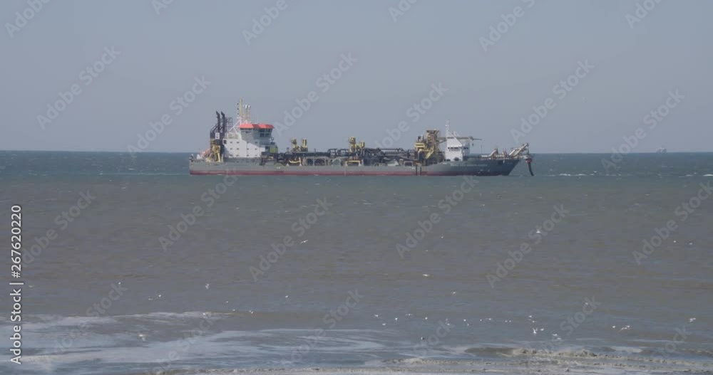 sand dredger at sea, suction hopper with tube attached sand dredger at sea, suction hopper with tube attached
