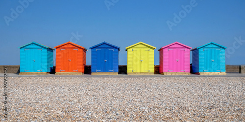 Fotografie a line of six multicoloured beach huts on Seaford beach, in the foreground is a