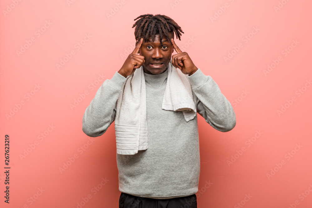Young fitness african black man focused on a task, keeping him forefingers pointing head. Young fitness african black man focused on a task, keeping him forefingers pointing head.