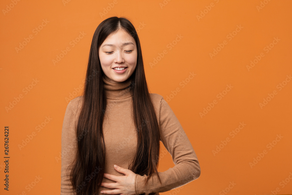 Young pretty chinese woman touches tummy, smiles gently, eating and satisfaction concept. Young pretty chinese woman touches tummy, smiles gently, eating and satisfaction concept.