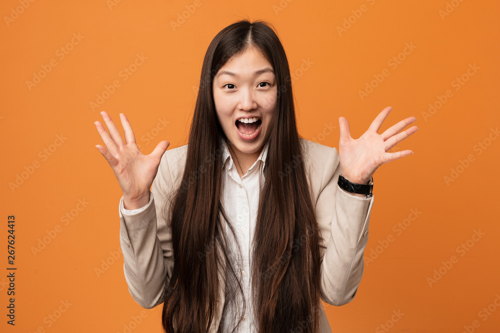 Young business chinese woman celebrating a victory or success