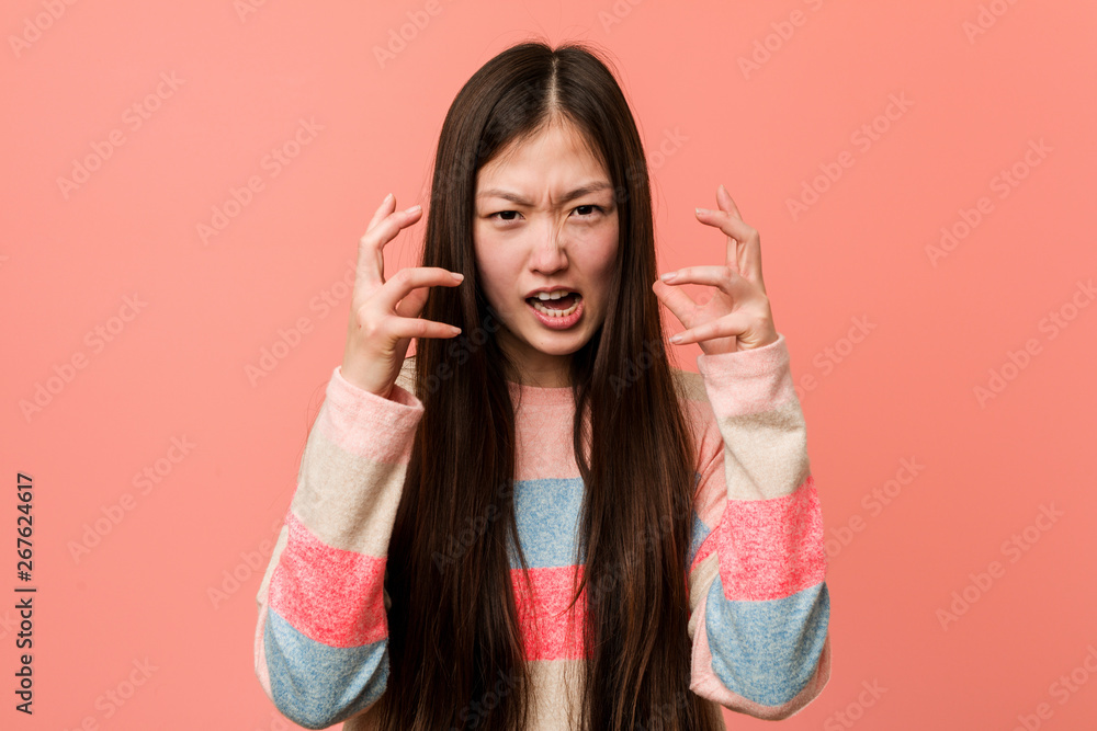 Young cool chinese woman upset screaming with tense hands. Young cool chinese woman upset screaming with tense hands.