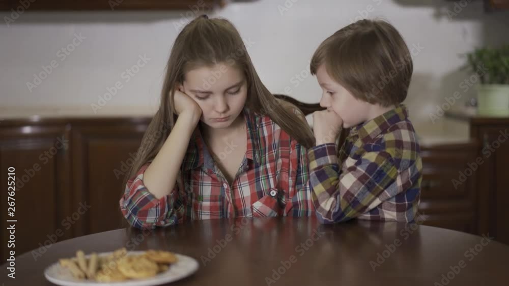 Portrait adorable small boy whispering secret to elder sister girl. Loving friendly family, happy kids. Portrait adorable small boy whispering secret to elder sister girl. Loving friendly family, happy kids.