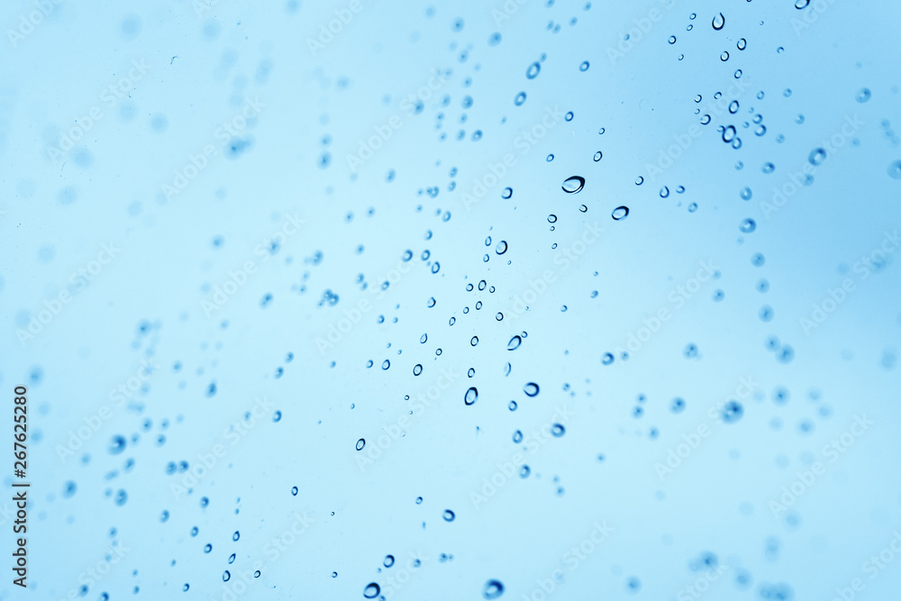 Gouttelettes de pluie sur une fenêtre bleue Gouttelettes de pluie sur une fenêtre bleue