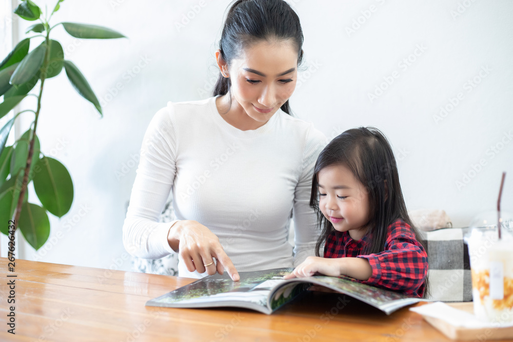 Mom is teaching her daughter to read a book.. Mom is teaching her daughter to read a book..