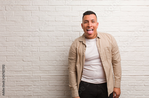 Young latin man funnny and friendly showing tongue