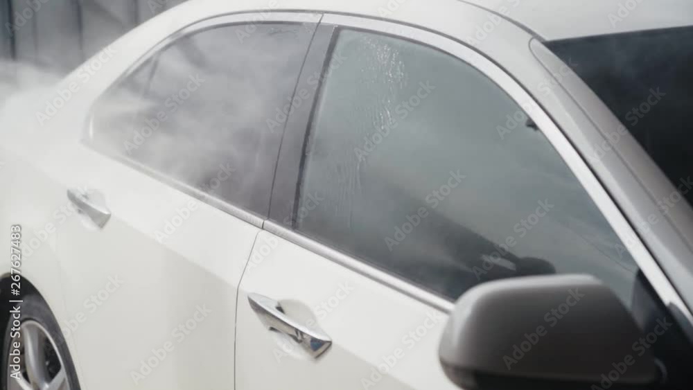 Car washing process. Applies wax to machine and clean it with jet of water. Slow motion Car washing process. Applies wax to machine and clean it with jet of water. Slow motion
