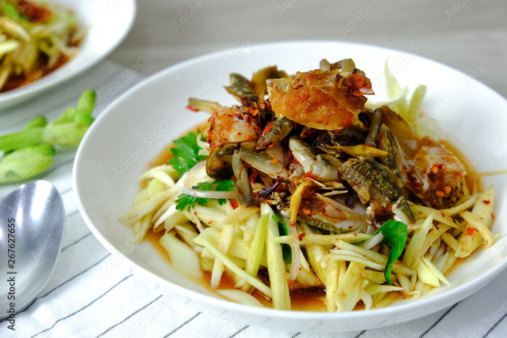 Papaya Salad with Crab. Thai food cuisine menu “Somtum”. It’s tasty, Spicy, Sour and Salty. Famous in Thailand and Lao. Close up Dish with fork on wooden background. Papaya Salad with Crab. Thai food cuisine menu “Somtum”. It’s tasty, Spicy, Sour and Salty. Famous in Thailand and Lao. Close up Dish with fork on wooden background.