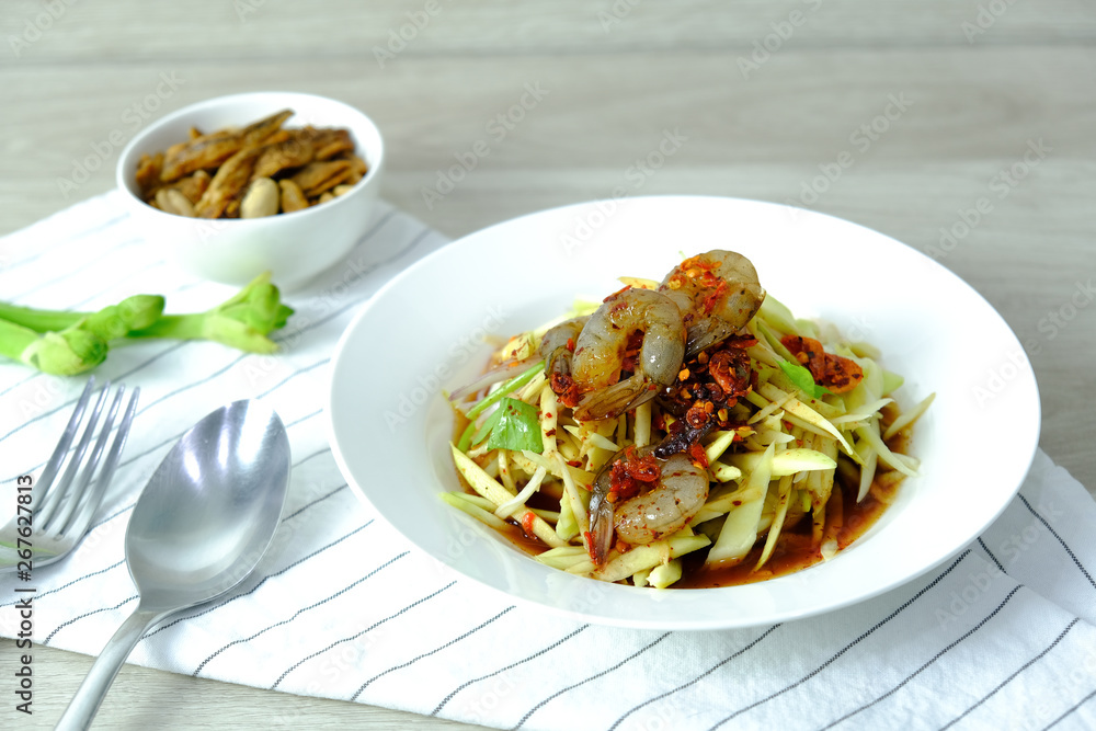 Papaya Salad with Shrimp. Thai food cuisine menu “Somtum”. It’s tasty, Spicy, Sour and Salty. Famous in Thailand and Lao. Close up Dish with fork on wooden background. Papaya Salad with Shrimp. Thai food cuisine menu “Somtum”. It’s tasty, Spicy, Sour and Salty. Famous in Thailand and Lao. Close up Dish with fork on wooden background.