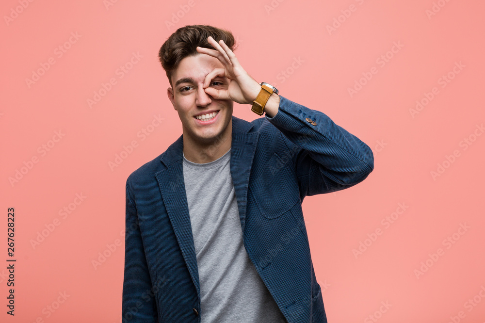 Young business natural man excited keeping ok gesture on eye. Young business natural man excited keeping ok gesture on eye.