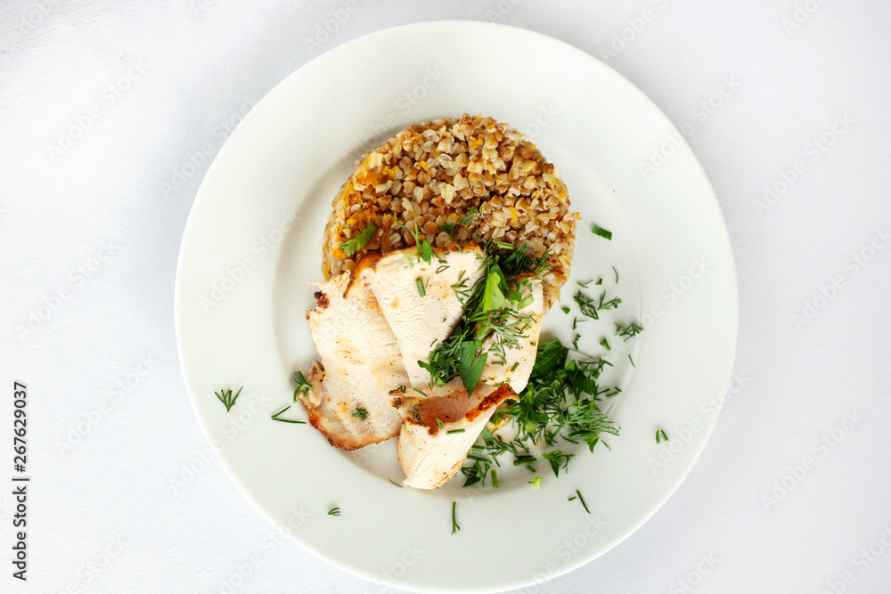 Chicken breast, buckwheat salad with greens on a white plate. Chicken breast, buckwheat salad with greens on a white plate.