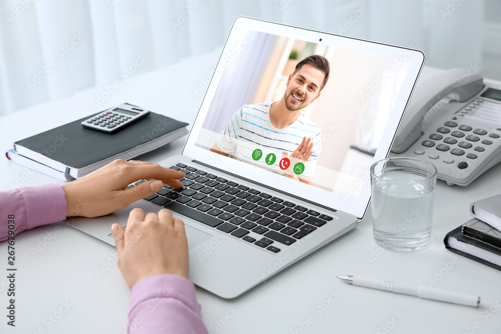 Woman using laptop for conversation with man via video chat at table, closeup Woman using laptop for conversation with man via video chat at table, closeup