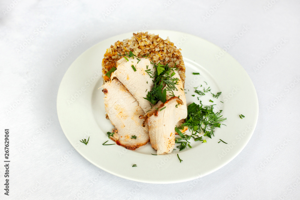 Chicken breast, buckwheat salad with greens on a white plate. Chicken breast, buckwheat salad with greens on a white plate.