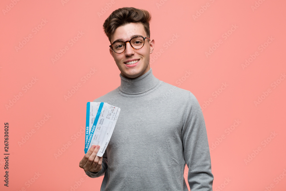 Young handsome man holding an air tickets happy, smiling and cheerful. Young handsome man holding an air tickets happy, smiling and cheerful.