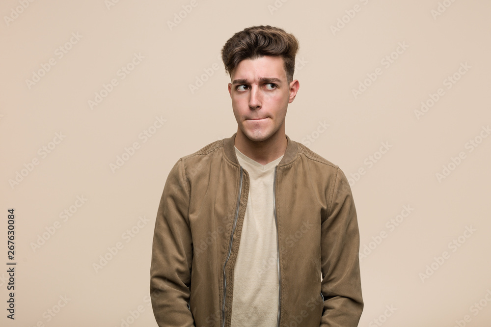 Young caucasian man wearing a brown jacket confused, feels doubtful and unsure. Young caucasian man wearing a brown jacket confused, feels doubtful and unsure.