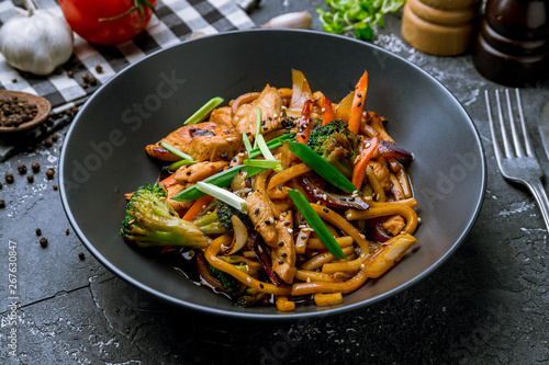 chicken wok noodles on black plate
