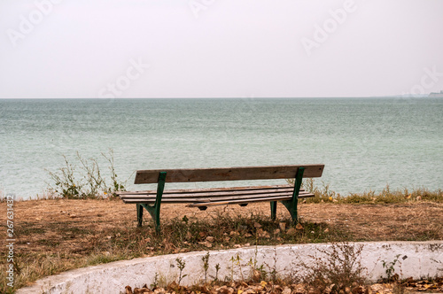 Lonely empty wooden obsolete vintage bench on the seashore