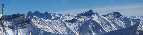 Panoramic view of snowy mountains at sun winter day