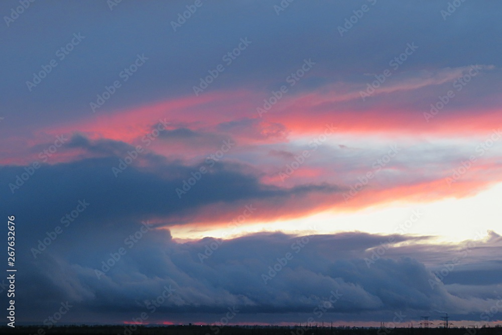 Beautiful dark sunset background with black dramatic clouds in the sky