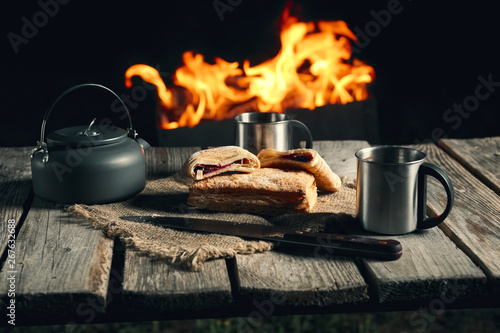 Late snack for two at night outdoor kamping - biscuit and tea near fireplace. photo