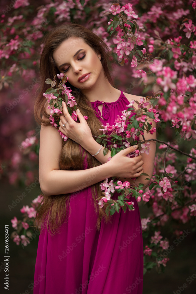 Romantic portrait of young attractive woman in blooming pink apple garden Romantic portrait of young attractive woman in blooming pink apple garden