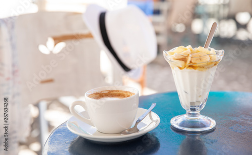 Light and tasty summer holidays breakfast cap of coffee cappuccino and yogurt with sliced banana, pear topped with honey in the Kiparissi Lakonia village, Peloponnese, Greece. photo