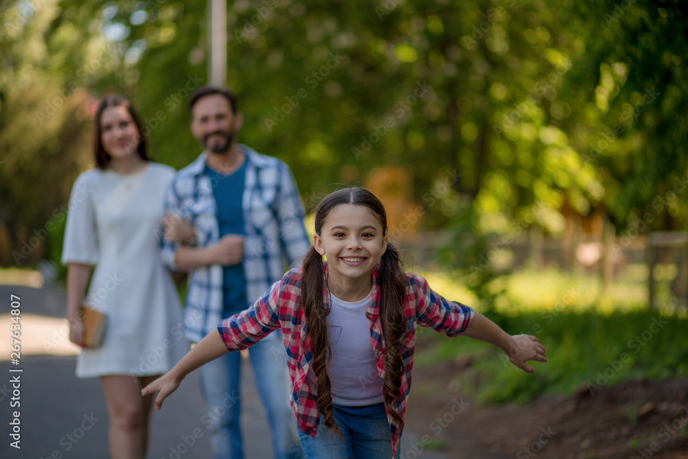Fototapeta premium Smiling family with a skateboard in summer park