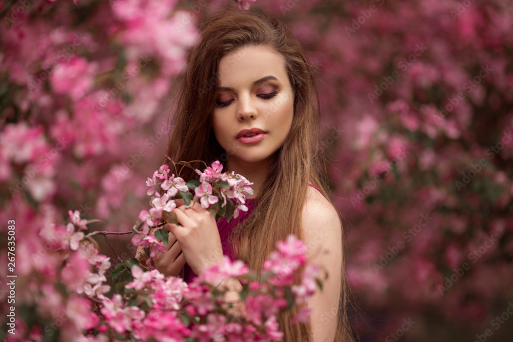 Beautiful girl in blossom apple garden with pink flowers, spring time Beautiful girl in blossom apple garden with pink flowers, spring time