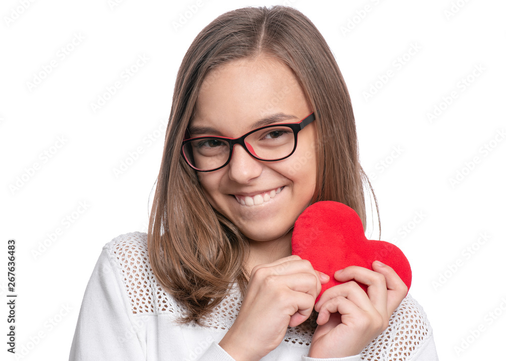 Happy Valentines Day. Cute young Teen Girl in Eyeglasses with Red plush Heart. Portrait of Smiling Child with Love looking at camera, isolated on white background. Happy Valentines Day. Cute young Teen Girl in Eyeglasses with Red plush Heart. Portrait of Smiling Child with Love looking at camera, isolated on white background.