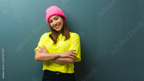 Young modern woman crossing arms, smiling and relaxed