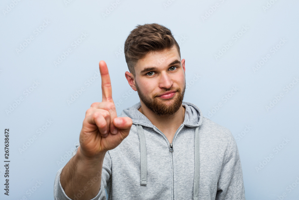 Young handsome fitness man showing number one with finger. Young handsome fitness man showing number one with finger.
