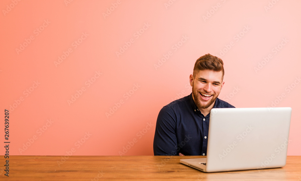 Young man working with his laptop laughing and having fun. Young man working with his laptop laughing and having fun.
