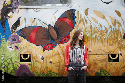 Smiling teenage girl standing at a painted train car photo