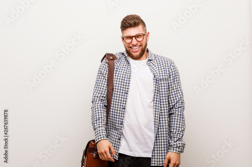 Young modern business man laughs and closes eyes, feels relaxed and happy.