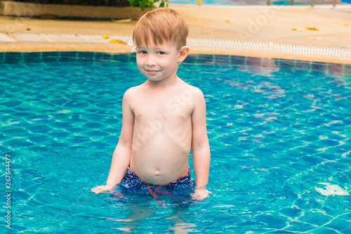 The boy stands in the water in the pool. © lazurny
