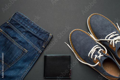 Mens summer casual clothes flat lay. Jeans, shoes and wallet. Mens summer casual clothing outfits and accessories flat lay on dark background, top view, fashion concept, copy space for text