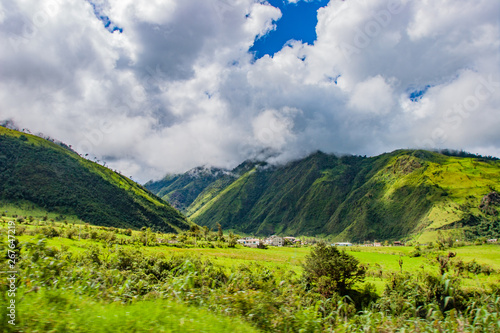 South America. Ecuador. Ecuador village in the lowlands of the Andes. Ecuadorian rural settlement. Andes mountains greenery covered with cloudy tops. Mountain landscape of Ecuador. 