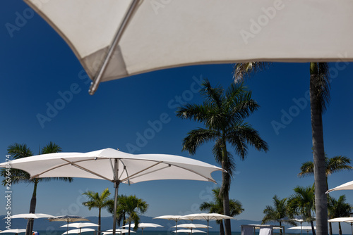 Resort pool umbrellas Nuevo Vallarta Mexico with Sierra Madre mountains and palm trees