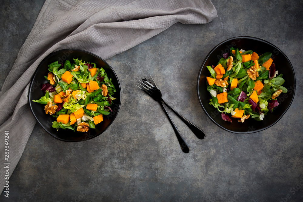 © Westend61 - Two bowls of mixed green salad with Hokkaido pumpkin and walnuts