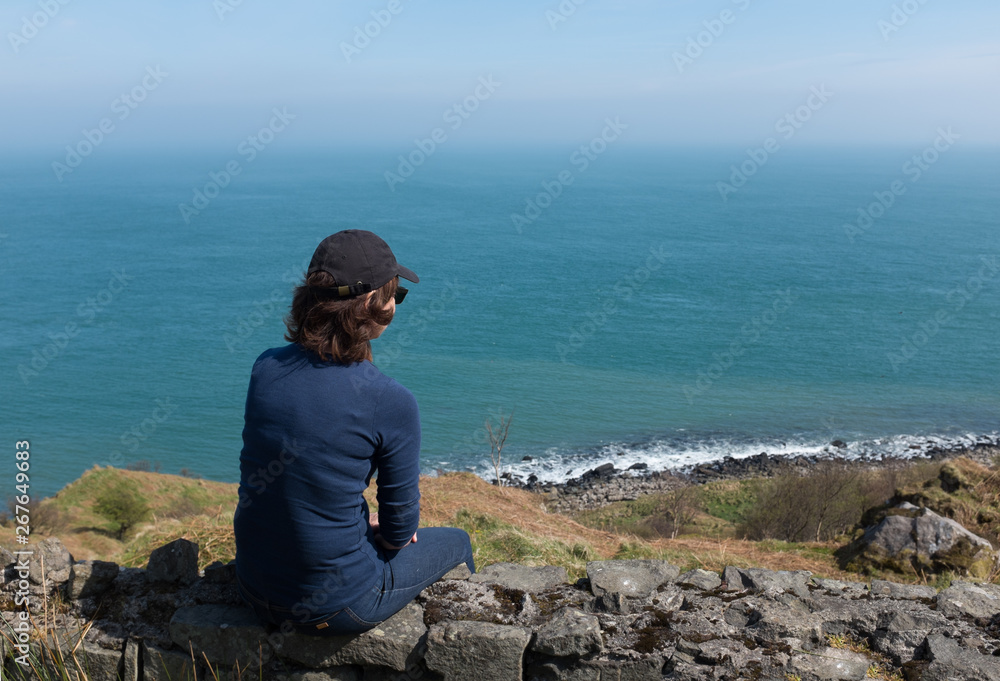 Woman looking at ocean back to camera, sunny day Woman looking at ocean back to camera, sunny day