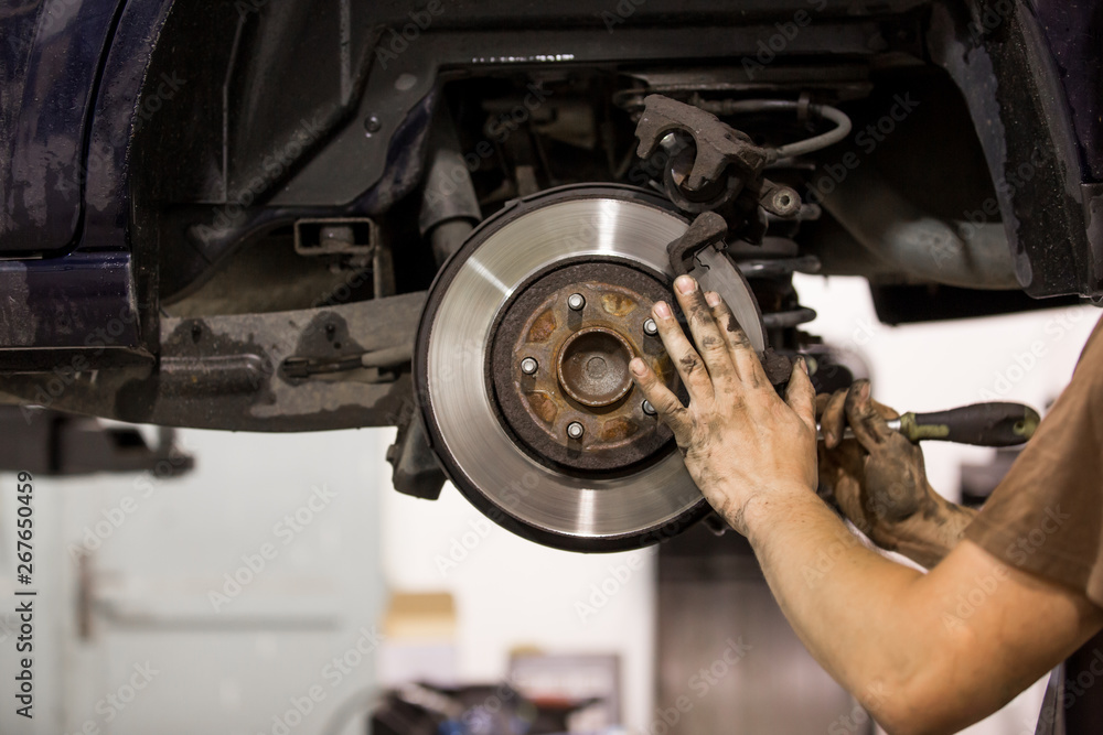 Car mechanic replacing pads for car break, transportation concept Car mechanic replacing pads for car break, transportation concept